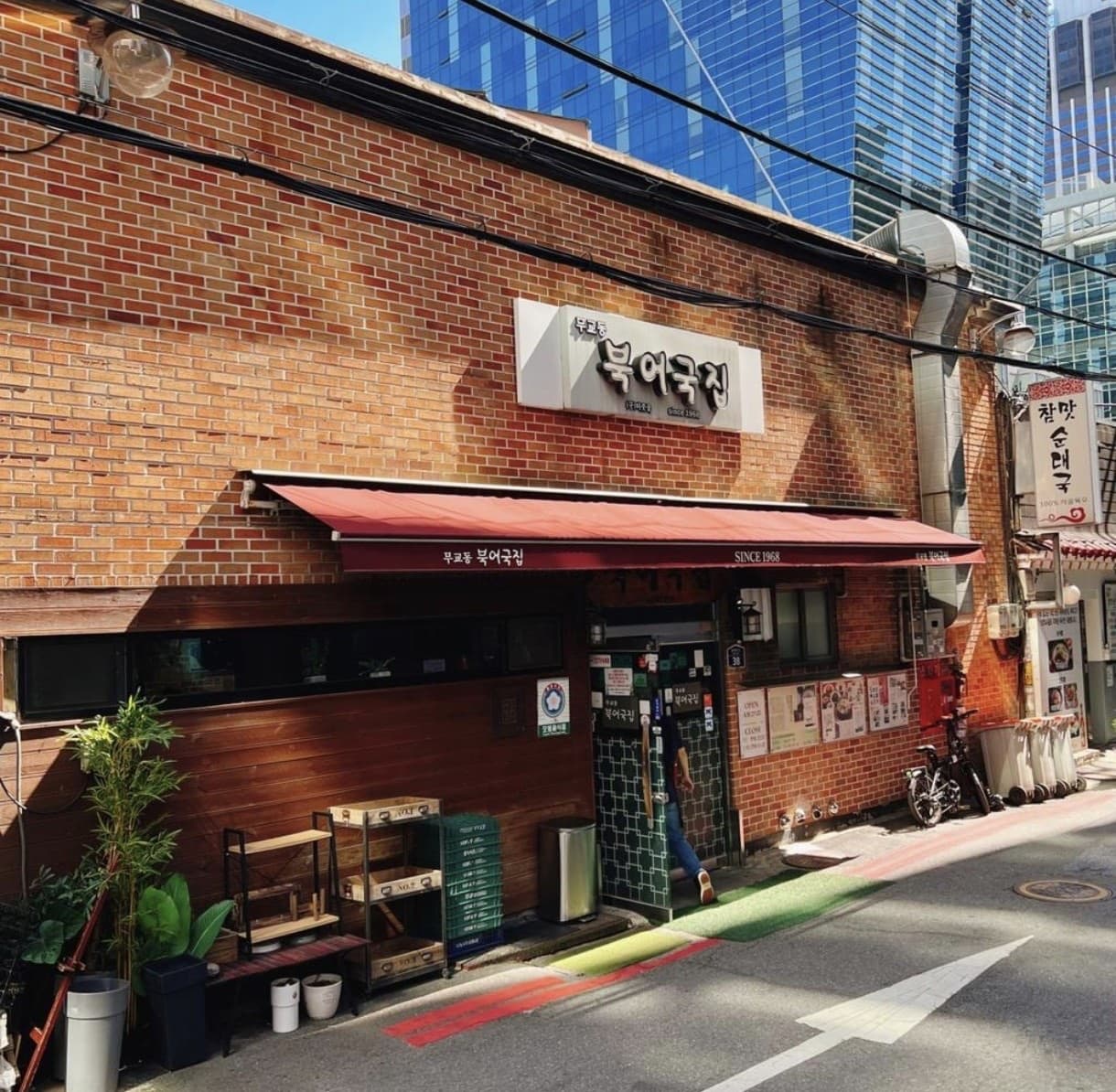 The brick-building storefront of Mugyo-dong Buk-eo-gukjip, open since 1968, with a red awning down a Seoul side street