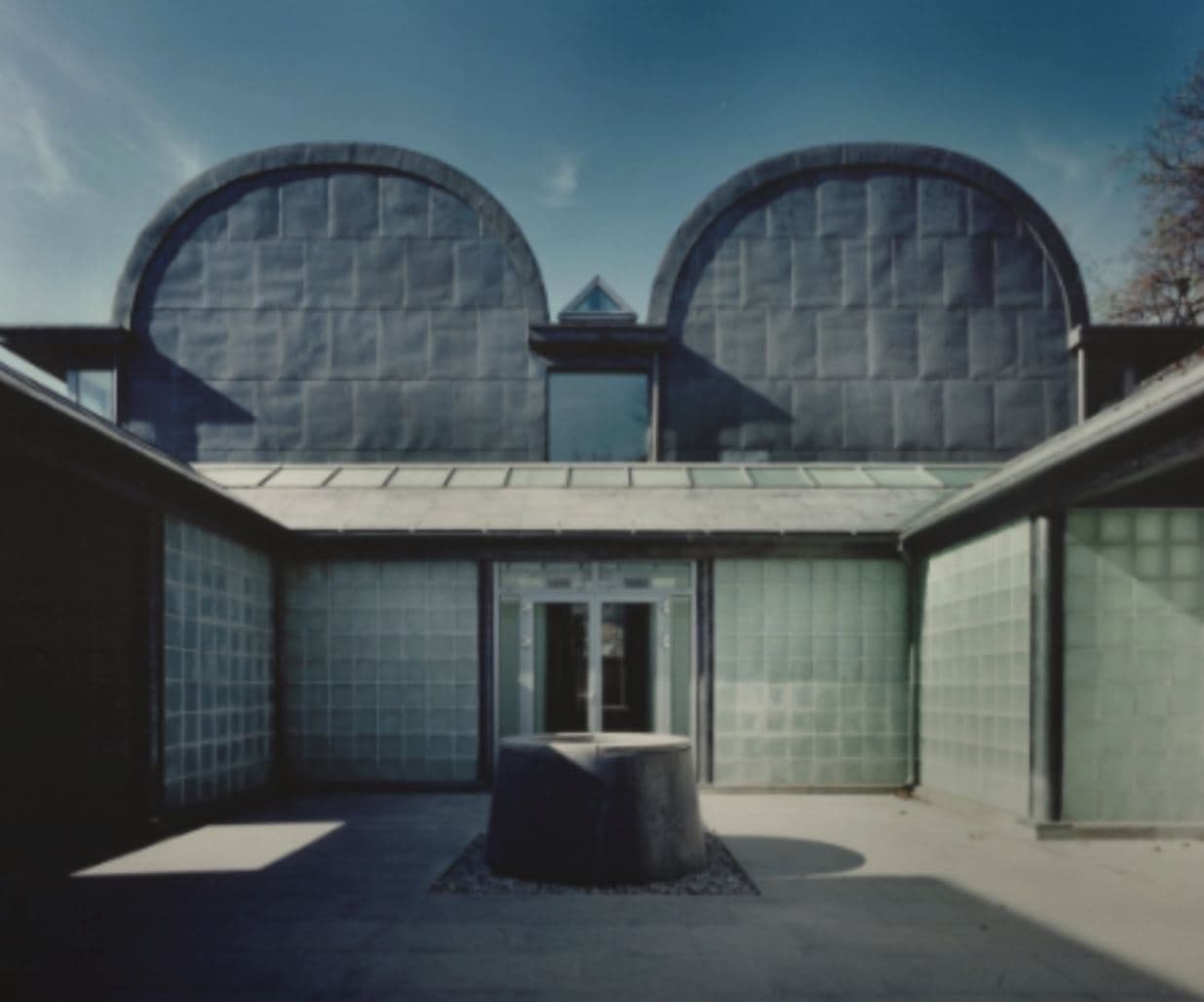 The Whanki Museum's distinctive exterior with twin barrel-vaulted roofs above a glass-block courtyard